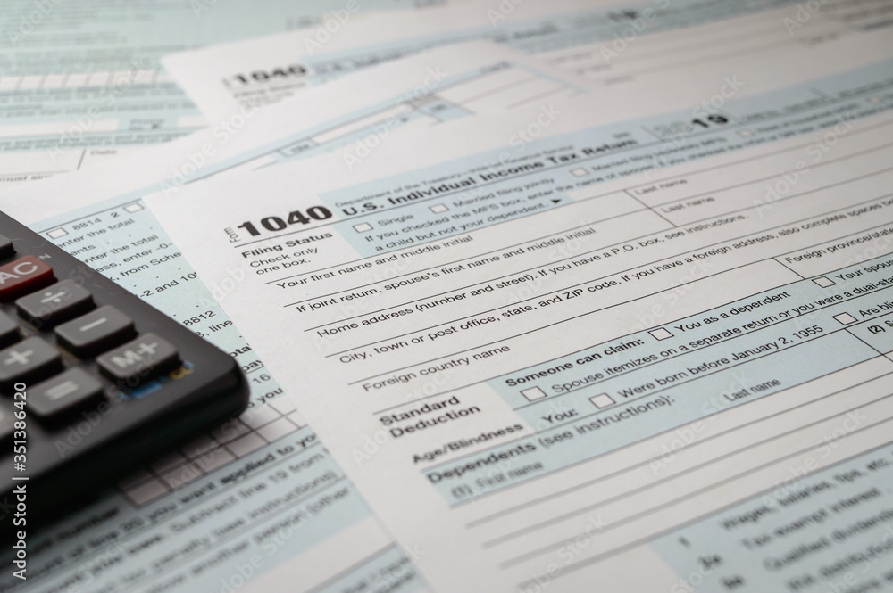 Tax form business financial concept: close up view of individual income tax return form 2019 and black calculator Tax form business financial concept: close up view of individual income tax return form 2019 and black calculator