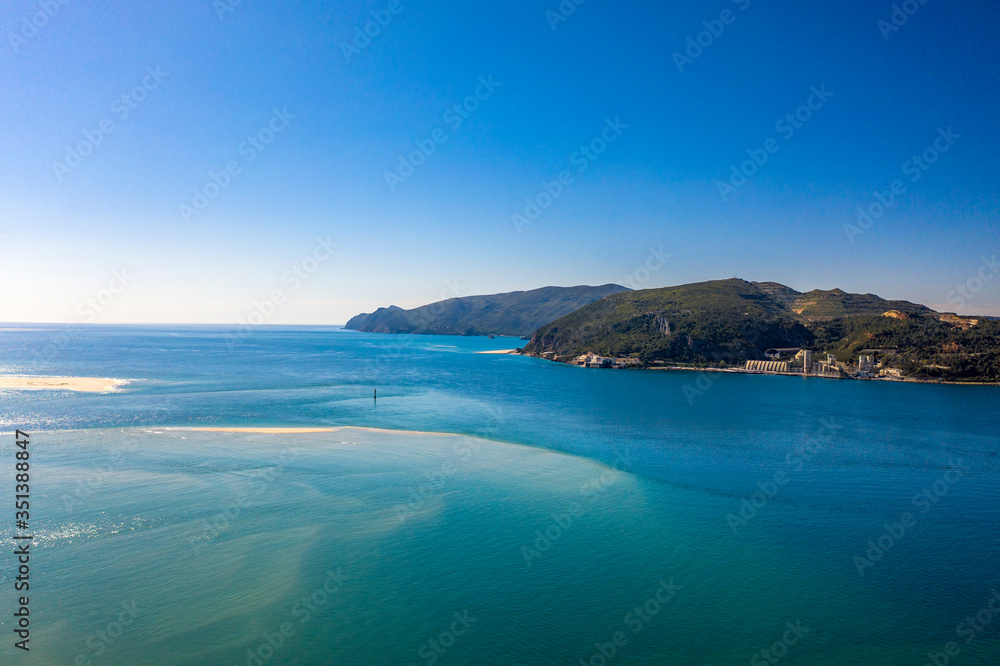 Landscape view of Tagus River mouth. Desert beach in Troia, Setubal, Portugal. Arrabida mountain in the background