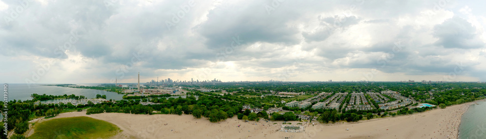 Toronto Woodbine Beach and sandy beach with people swimming, aerial view, Ontario, Canada, rainy cloudy greenery coast with boats at summer. Many residential houses. Popular tourist location