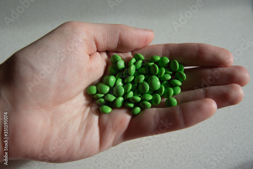 A lot of green pills in hand
