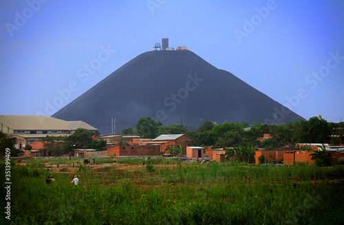 A famous 500 foot slag mountain made from copper mining residue rises above the countryside in Lubumbashi, D.R. Congo.