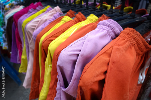 Fashion trousers on clothing rack - bright colorful closet.
