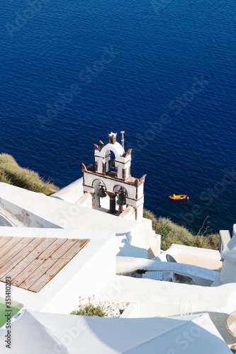 Bird view from the cliffs on bell tower and ocean in Oia, Santorini, Greece