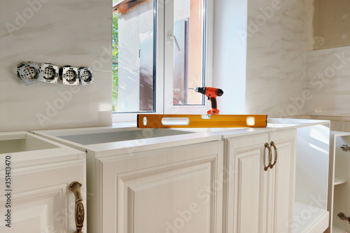 Obraz na plátne White kitchen furniture and yellow building level
