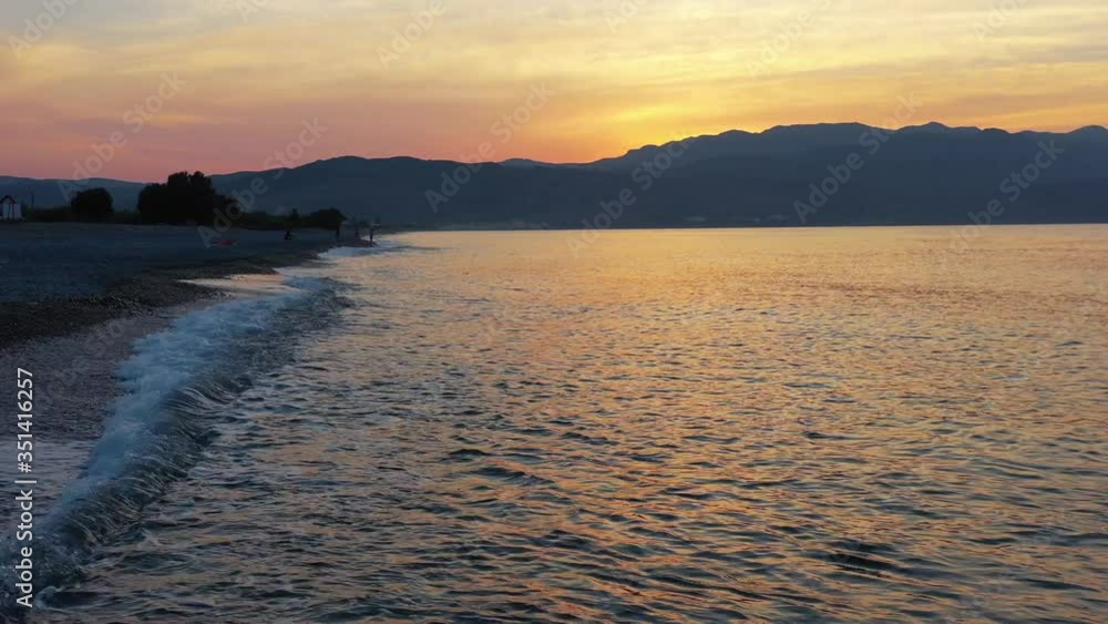 Aerial low-altitude video from drone on Platanias beachfront area, beach and sea at sunset time Aerial low-altitude video from drone on Platanias beachfront area, beach and sea at sunset time