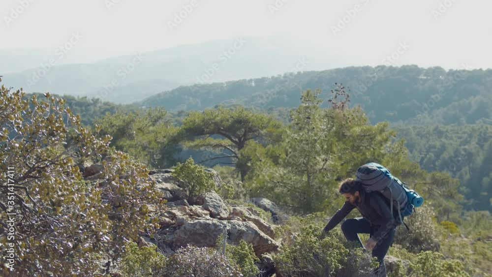 Sporty man standing on the stone against mountain valley Sporty man standing on the stone against mountain valley
