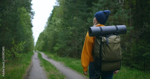Wallpaper Mural Slow motion: Young Woman Hiking in Forest in Autumn. Active healthy Caucasian woman with a backpack taking in wood. Female traveler with walks along forest rear view, leisure, bio-tourism, Hiking Torontodigital.ca