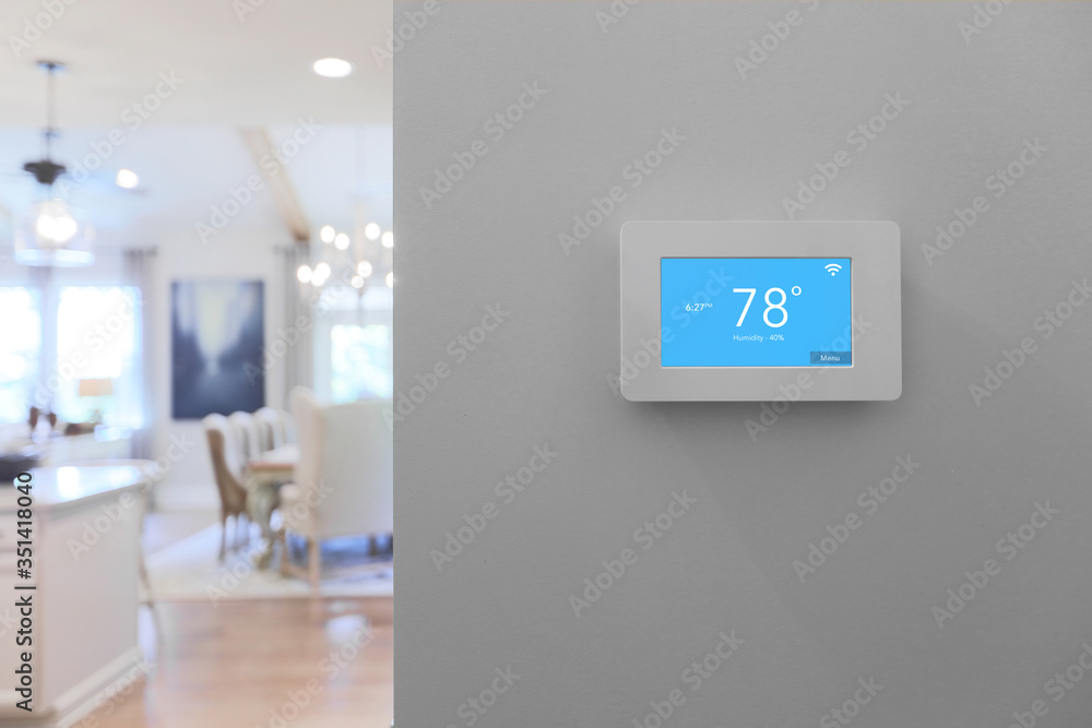 Home with smart thermostat mounted on wall with touchscreen  - obrazy, fototapety, plakaty 