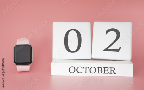 Modern Watch with cube calendar and date 02 october on pink background. Concept autumn time vacation.