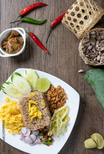 shrimp paste rice with caramelized pork condiment, dried shrimp, green mango, chilies, lime, shallot , cucumber. thai food called kao Kluk Kapi.top view. Flat lay.