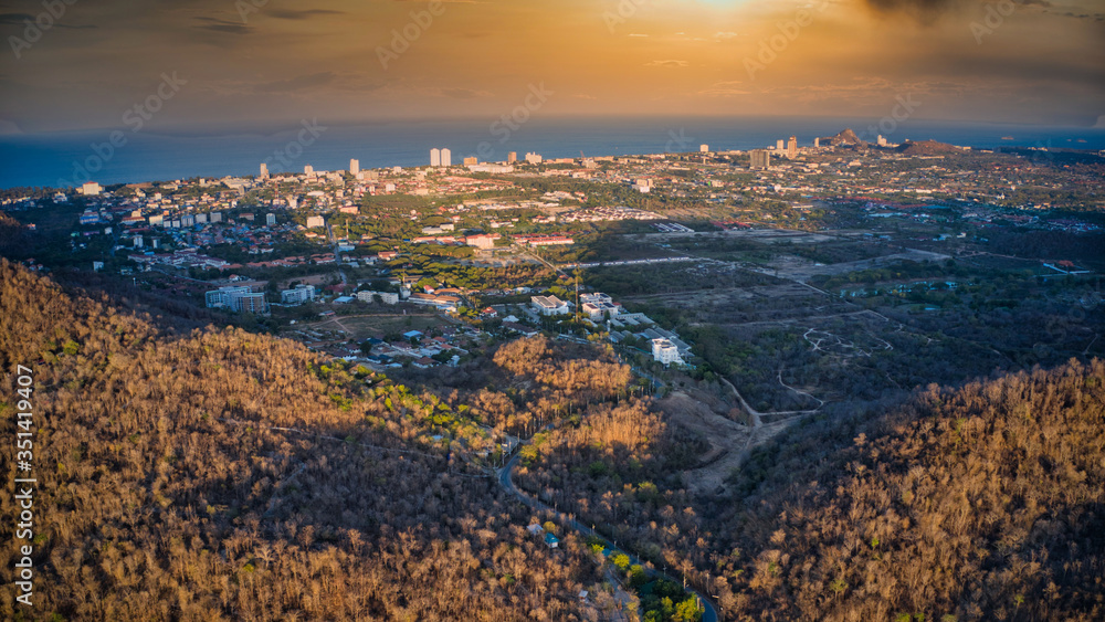 This unique photo shows the autumnal hilly landscape on the Hin lek fai during a sunset! The beautiful golden sky over the city of Hua Hin in the background. The picture was taken with a drone.