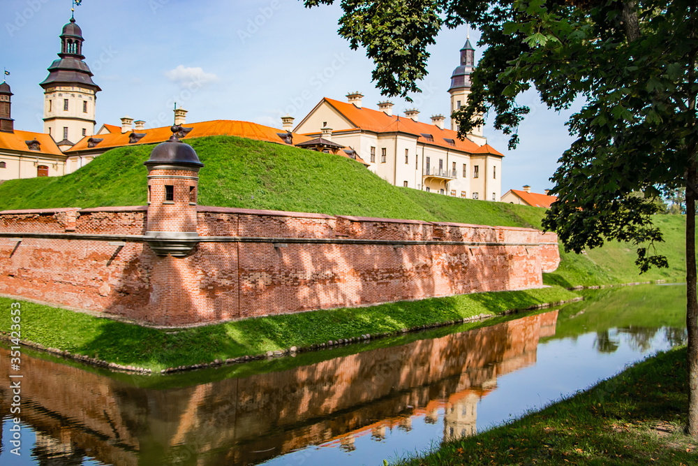 Nesvizh, Belarus. View of a medieval castle on a summer day. An ancient fortress is reflected in the water.