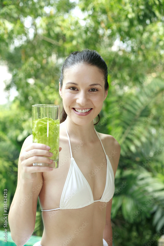 Woman holding a glass of herbal drink Woman holding a glass of herbal drink