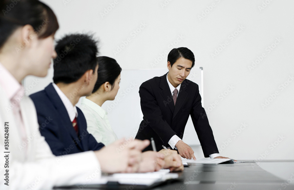 Businessman giving presentation to colleagues in board room Businessman giving presentation to colleagues in board room