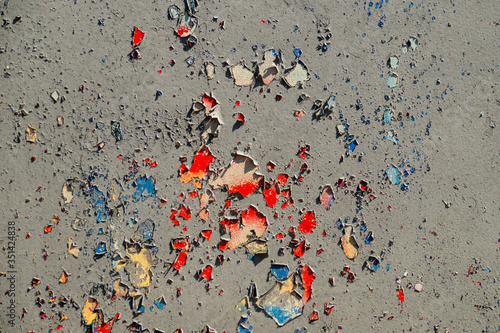 texture of a gray wall with red, yellow and blue spots visible from under the paint