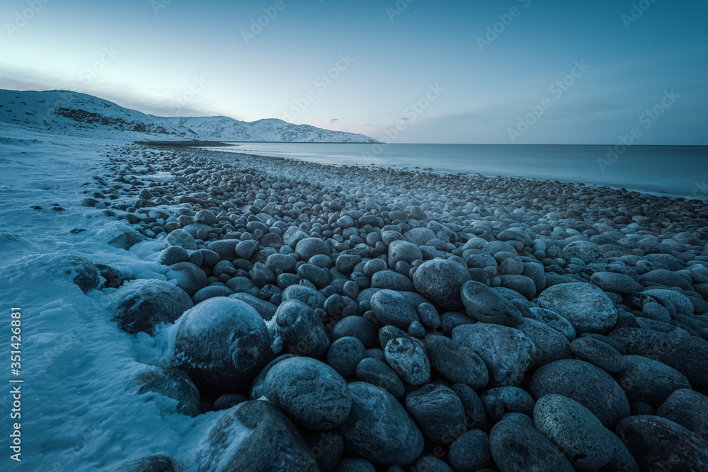 Waves break on the Gulf coast against the backdrop of snow-capped mountains of the Arctic Waves break on the Gulf coast against the backdrop of snow-capped mountains of the Arctic