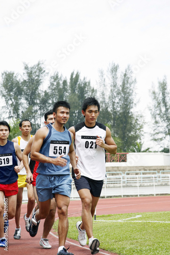 Men running in a race, close competition © ImageHit