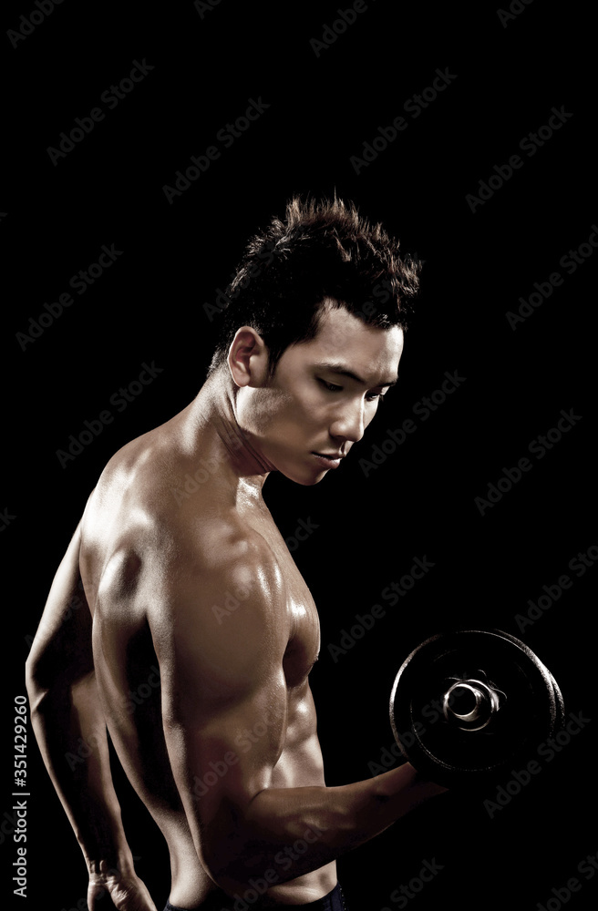 Muscular man lifting dumbbell Muscular man lifting dumbbell