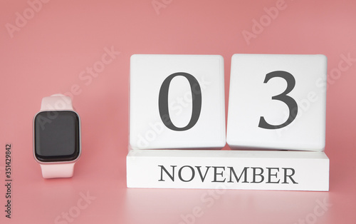 Modern Watch with cube calendar and date 03 november on pink background. Concept autumn time vacation.
