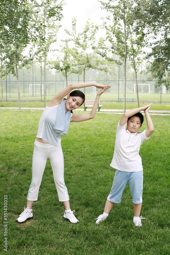 Woman and boy exercising in the park Woman and boy exercising in the park