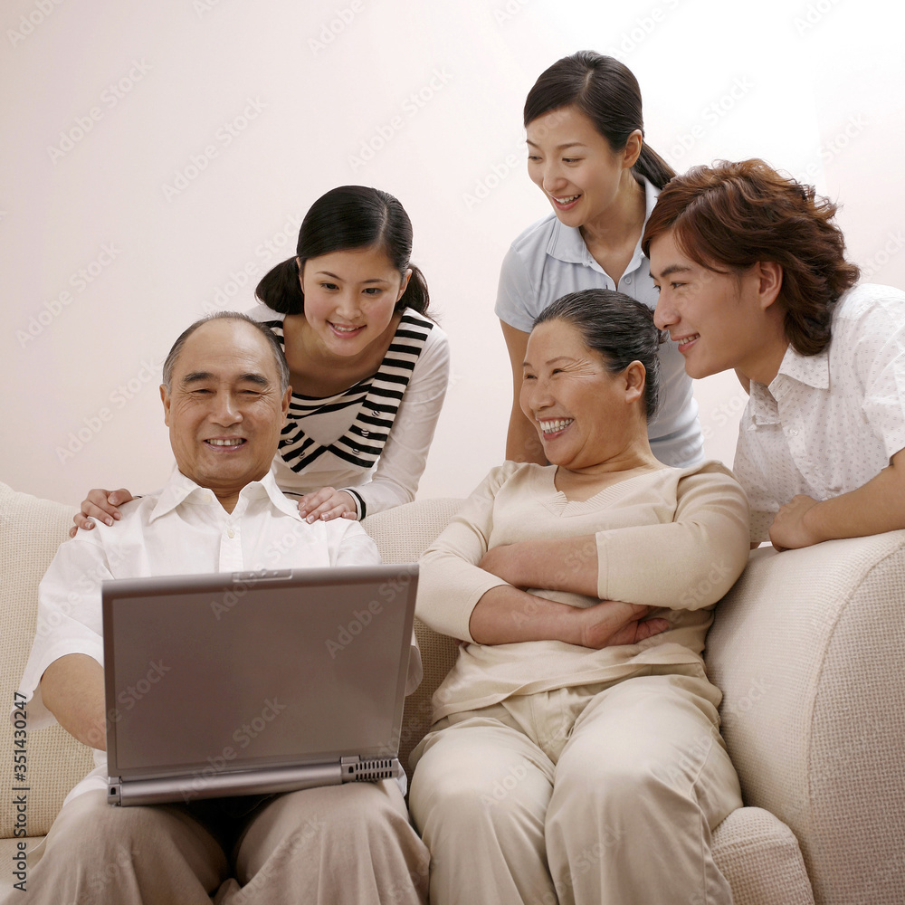Senior man using laptop with others are watching Senior man using laptop with others are watching