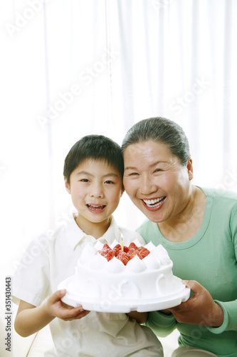 Senior woman and boy with a birthday cake