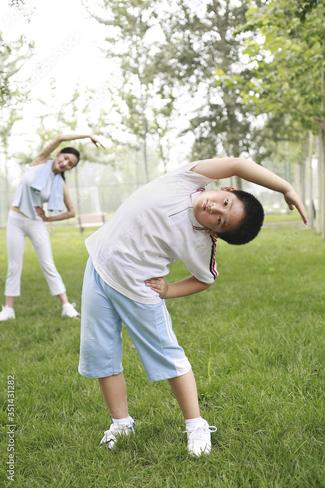 Woman and boy exercising in the park Woman and boy exercising in the park