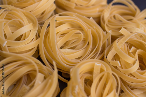 tagliatelle noodles on black background - closeup