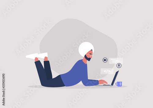 Young indian male character lying on the floor and typing on a laptop, working from home concept