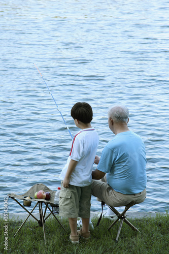 Senior man and boy fishing at the lake