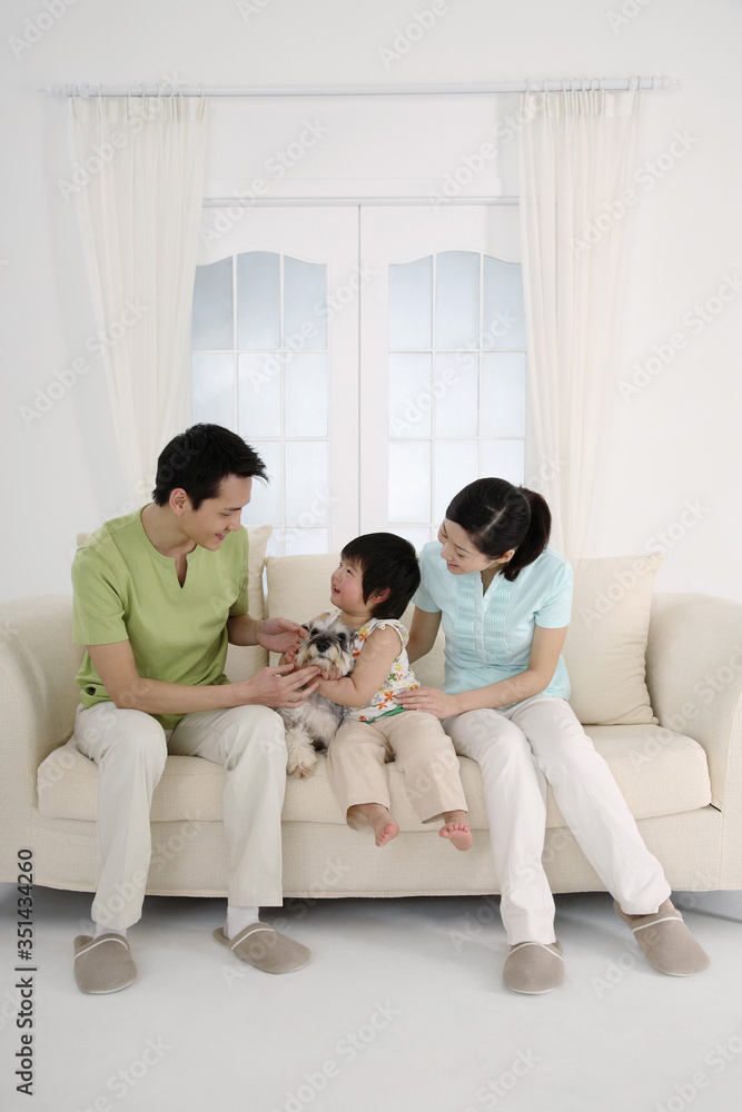 Man and woman playing with girl, girl cuddling dog Man and woman playing with girl, girl cuddling dog