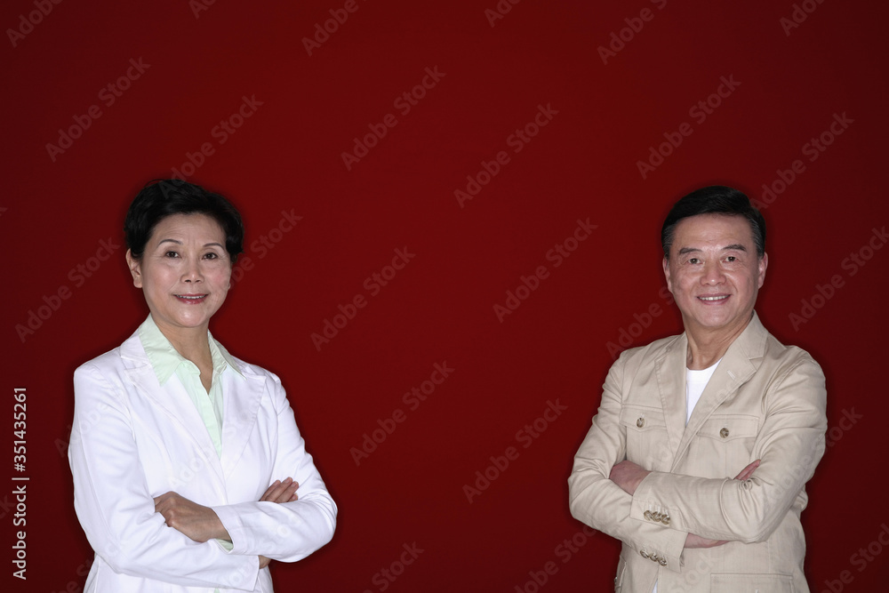 Senior man and senior woman posing with their arms folded Senior man and senior woman posing with their arms folded