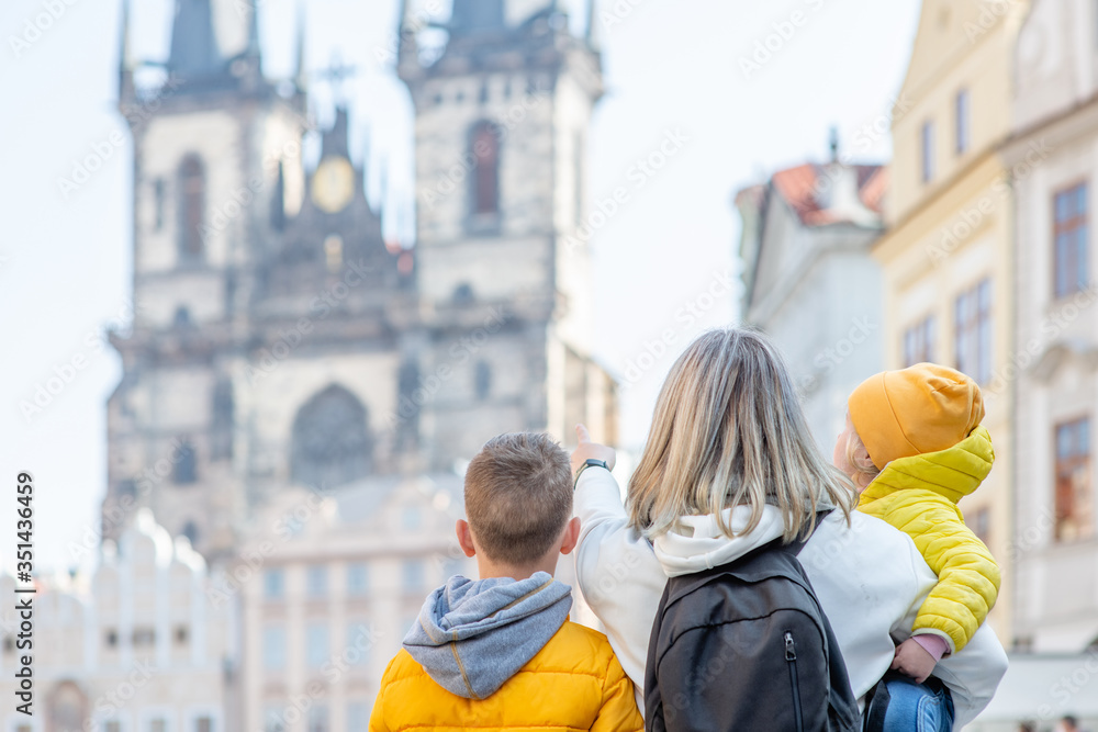 Happy family stands on the Old Town Square in Prague. Back view. Empty space for text