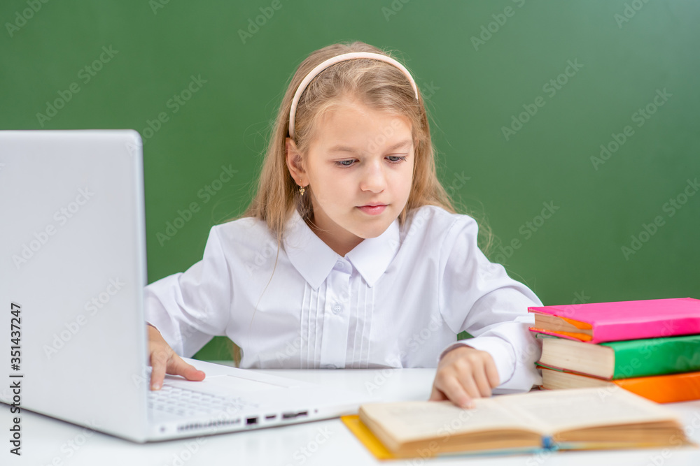Smart young girl uses laptop in a school Smart young girl uses laptop in a school