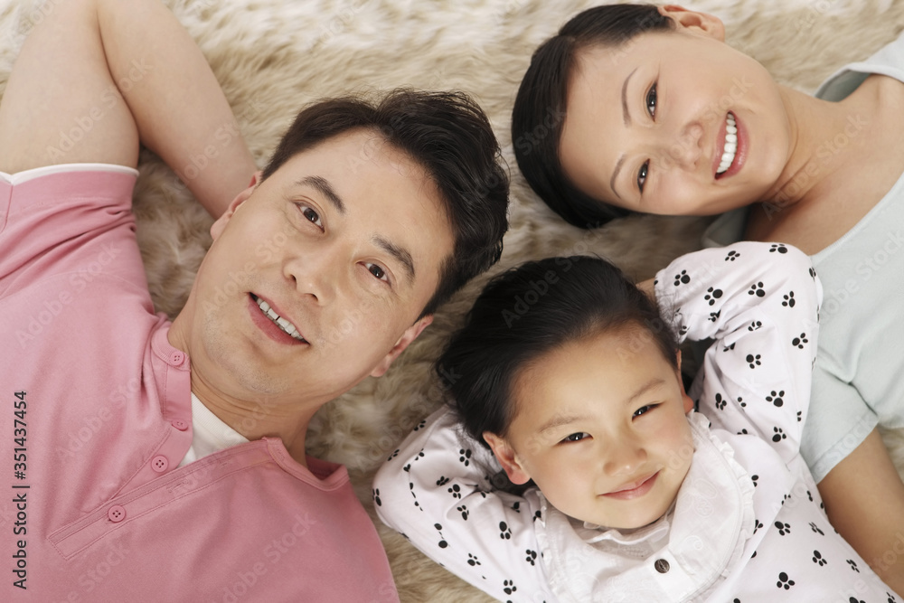 Family lying down on carpet smiling