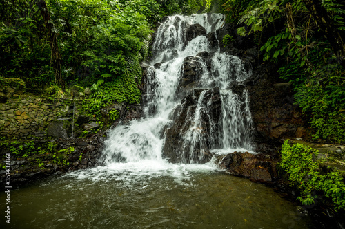 Waterfall landscape. Beautiful hidden Jembong waterfall in tropical rainforest in Ambengan, Bali. Slow shutter speed, motion photography.