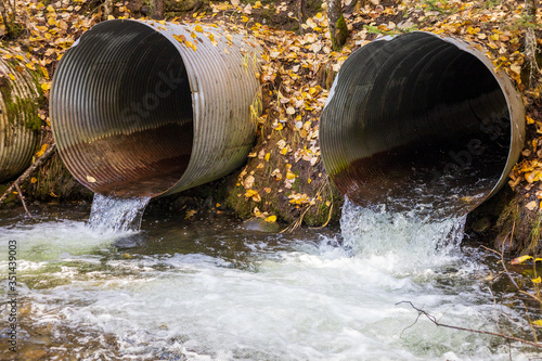 Old aging infrastructure. Three perched old and rusty culverts creating a barrier to fish in a stream on a forest road.