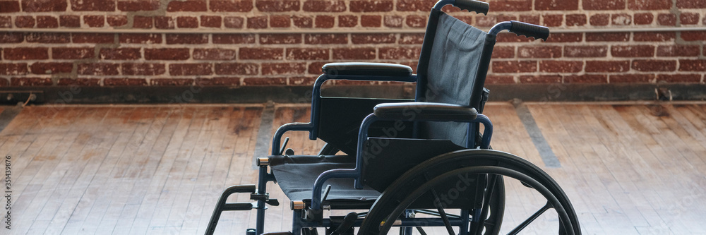 Fototapeta premium Empty wheelchair on a wooden floor