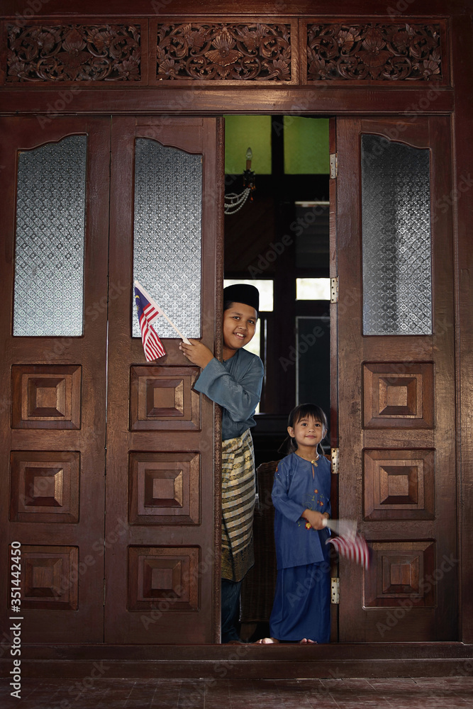 Boy and girl holding flag, standing at the doorway