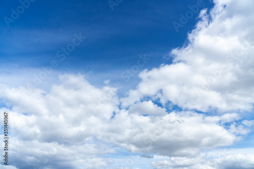 Overcast white clouds on the side of blue sky. Fluffy clouds background