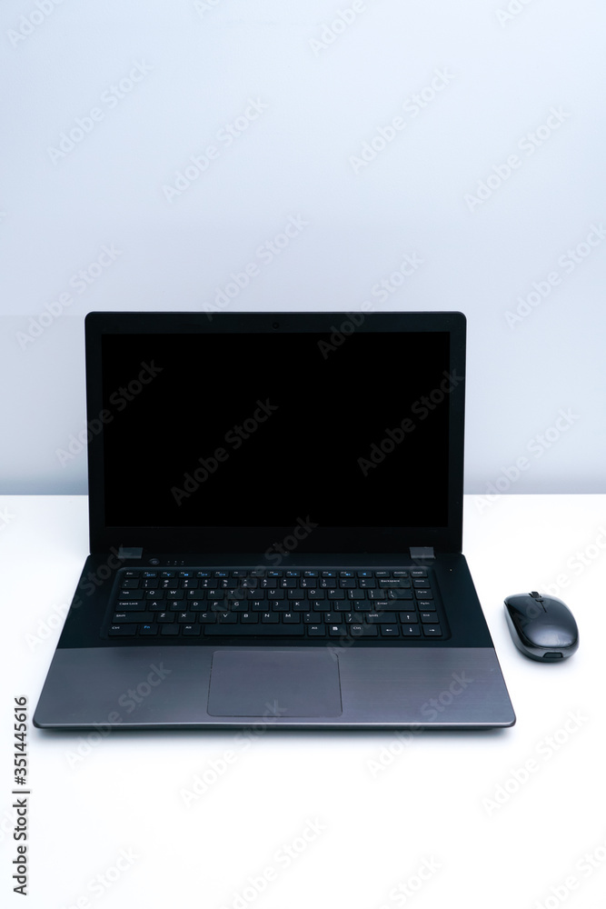 A dark gray laptop on a white desk. A dark gray laptop on a white desk.