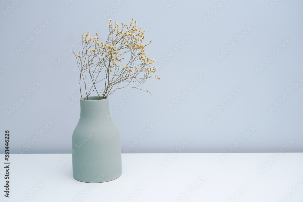 Put the vase with dried flowers on the white table