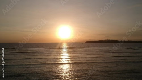 drone take off vertically during sunset with a huge yellow sun without clouds gili air