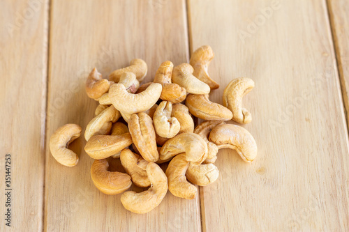 Many Roasted salted cashew nuts on wooden background