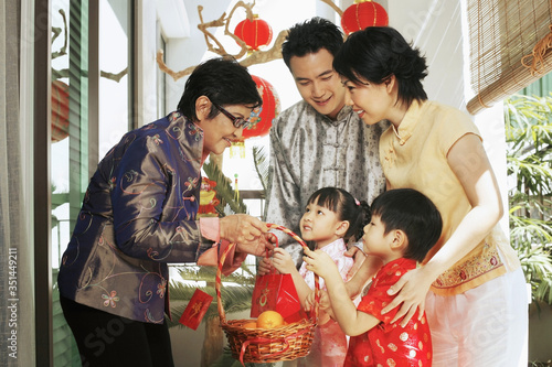 Couple with their children visiting senior woman