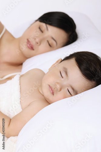 Woman sleeping beside baby girl