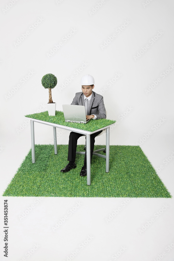 Fototapeta premium Businessman with safety helmet using laptop