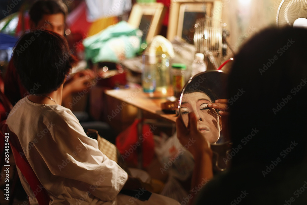 Opera performer applying make-up