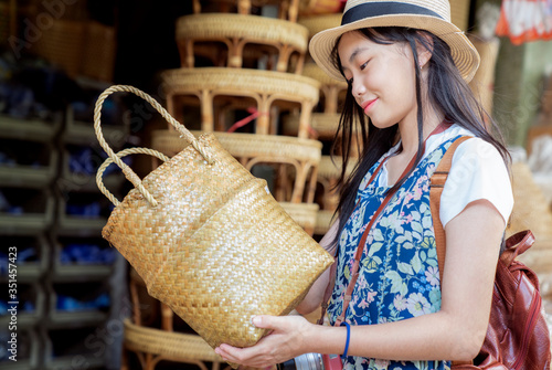 Fotografie Asian girl, travel and shopping in traditional basketry shop