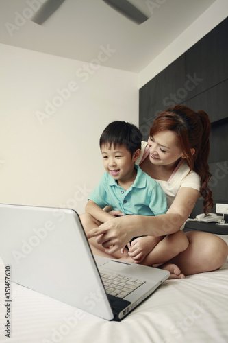Mother and son using laptop together